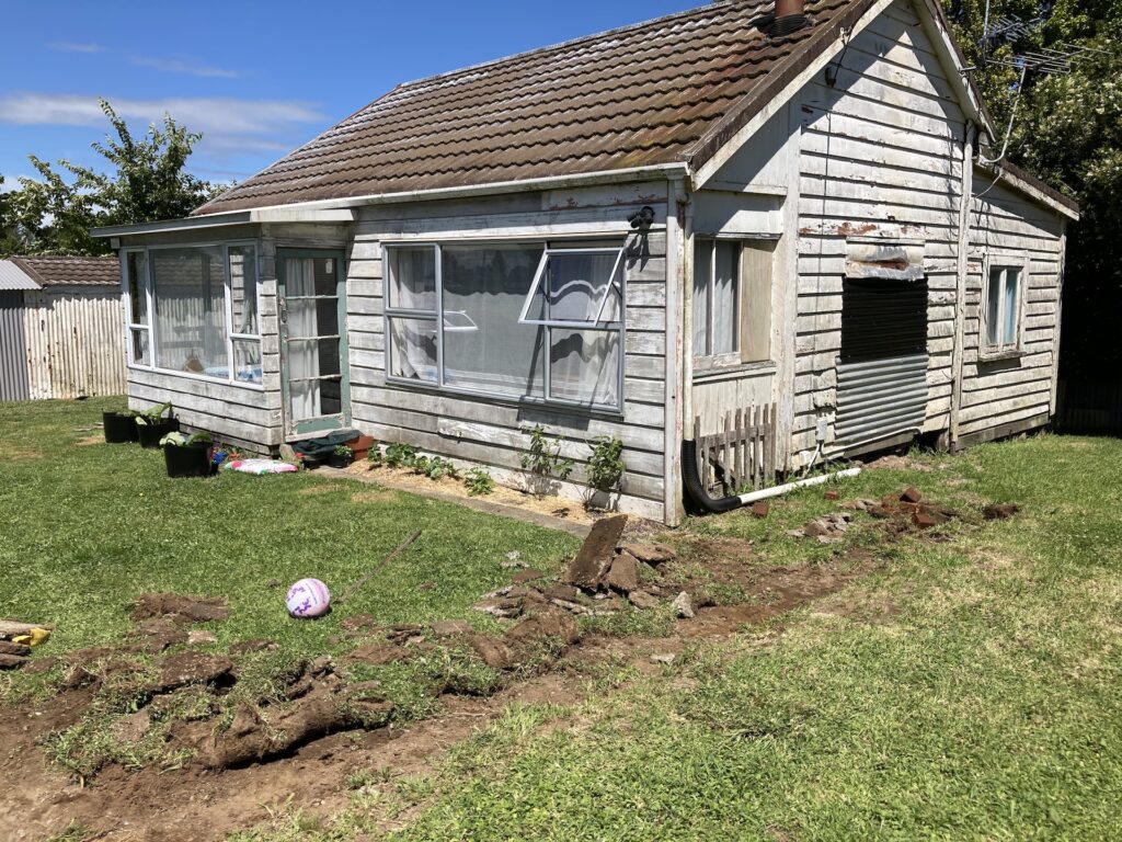 An old, untidy house with the grass dug up, a huge project for first time renovators